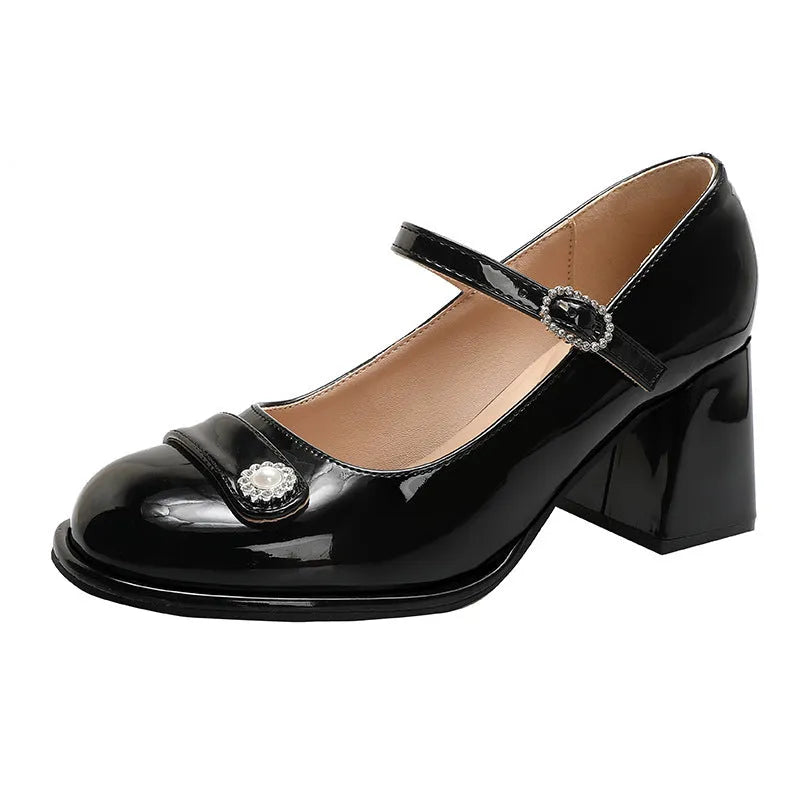 Women's black patent leather round toe shoes with a chunky block heel and buckle fastening.