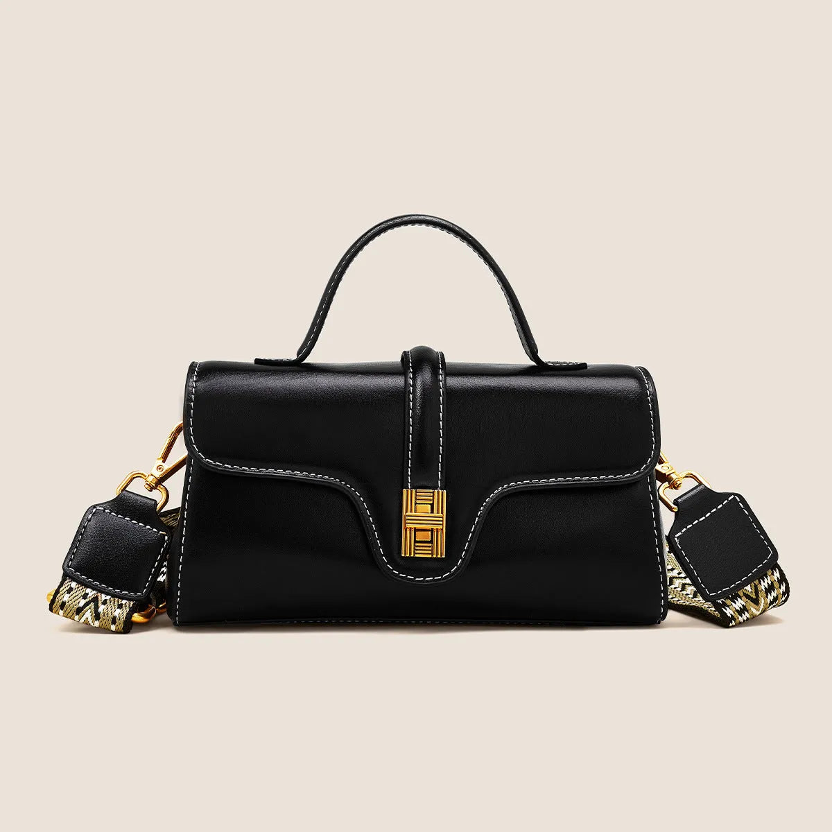 Brown Cambridge-style crossbody messenger bag with clamshell opening and lock detail on a table.