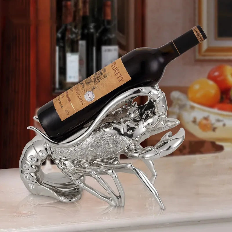 Decorative lobster-shaped wine rack ornament in rose gold or silver resin and plastic on a tabletop.