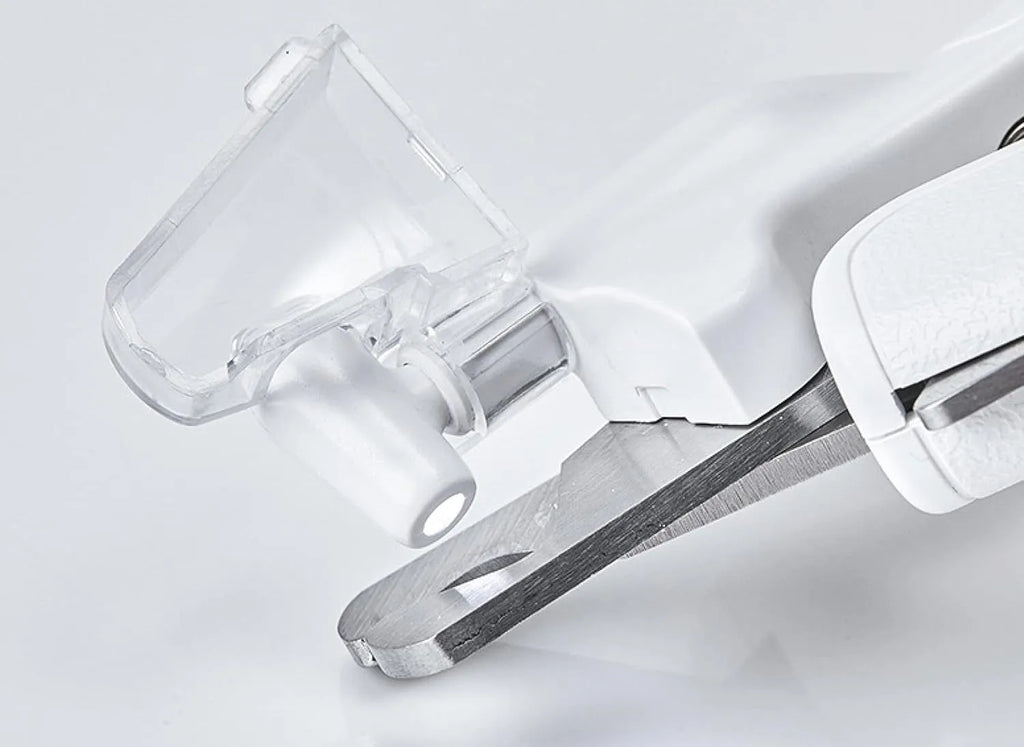 White pet nail clippers with LED light on blade and transparent anti-splash guard, shown with a nail file.