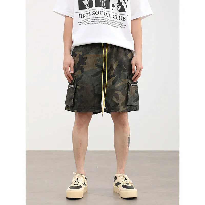 Men's camouflage multi-pocket cropped work shorts laid flat showing cargo pockets and camo pattern.