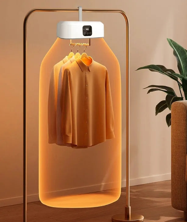 White cylindrical foldable portable clothes dryer with remote control on wooden surface