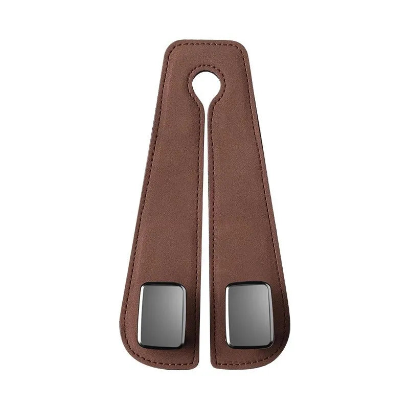 Black suede car seat hook attached to a headrest post, holding a shopping bag.