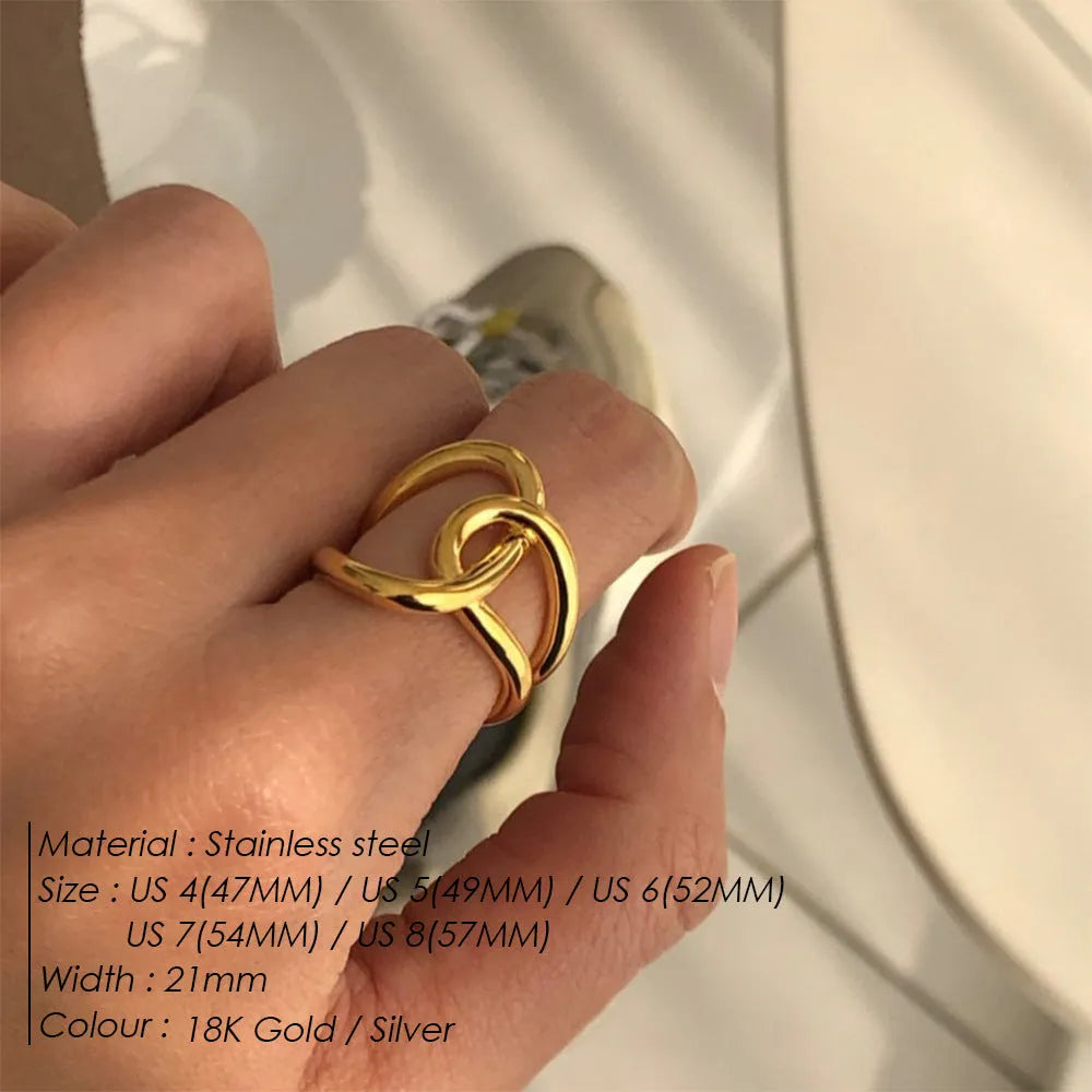 Women's stainless steel adjustable knotted open ring in gold or steel colour on a grey background.
