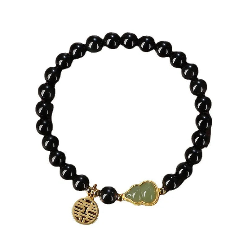 Black obsidian bracelet with a Hetian jade gourd pendant, showing geometric beads.