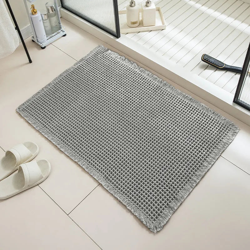 Checkered patterned absorbent bathroom carpet on floor showing non-slip woven base in beige colour.