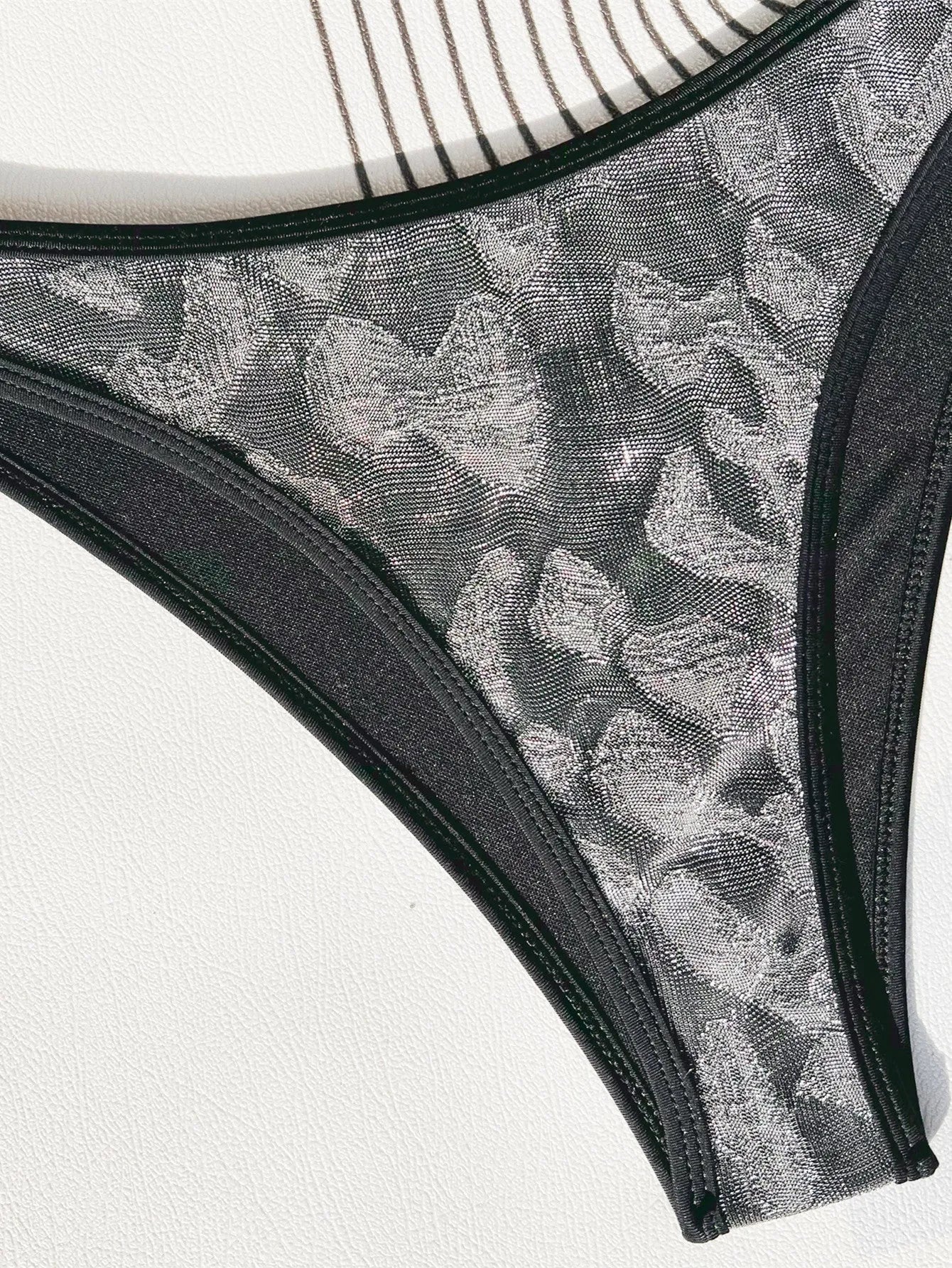 Black two-piece ladies bikini swimsuit with straps, made from polyester fabric.