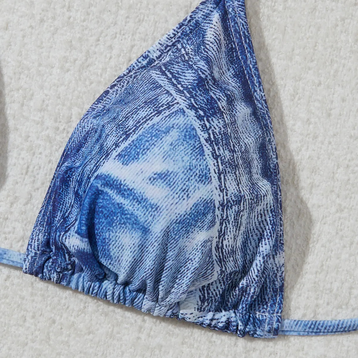 Denim blue women's bikini set with printed strap design on a hanger.