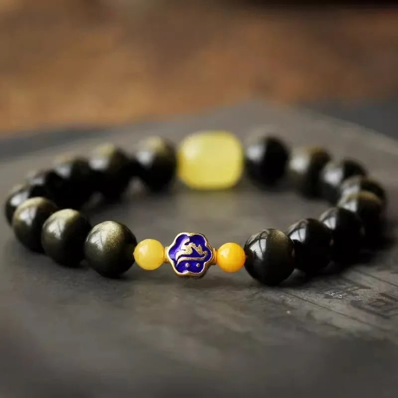 Handmade golden obsidian bracelet with 10mm geometric beads on a wrist, showing ethnic zodiac design.