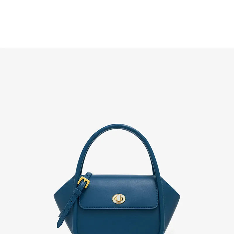 Women's wing-shaped leather tote bag with a latch buckle, shown in Atlantic blue with a cross-body strap.