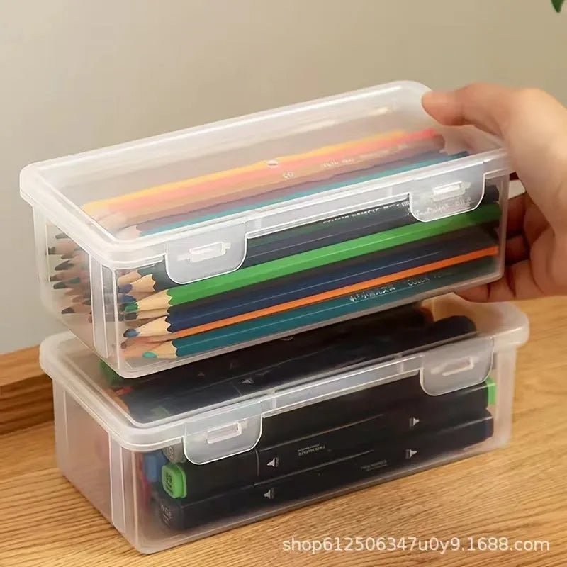 Transparent plastic stationery storage box containing colour pencils and drawing supplies