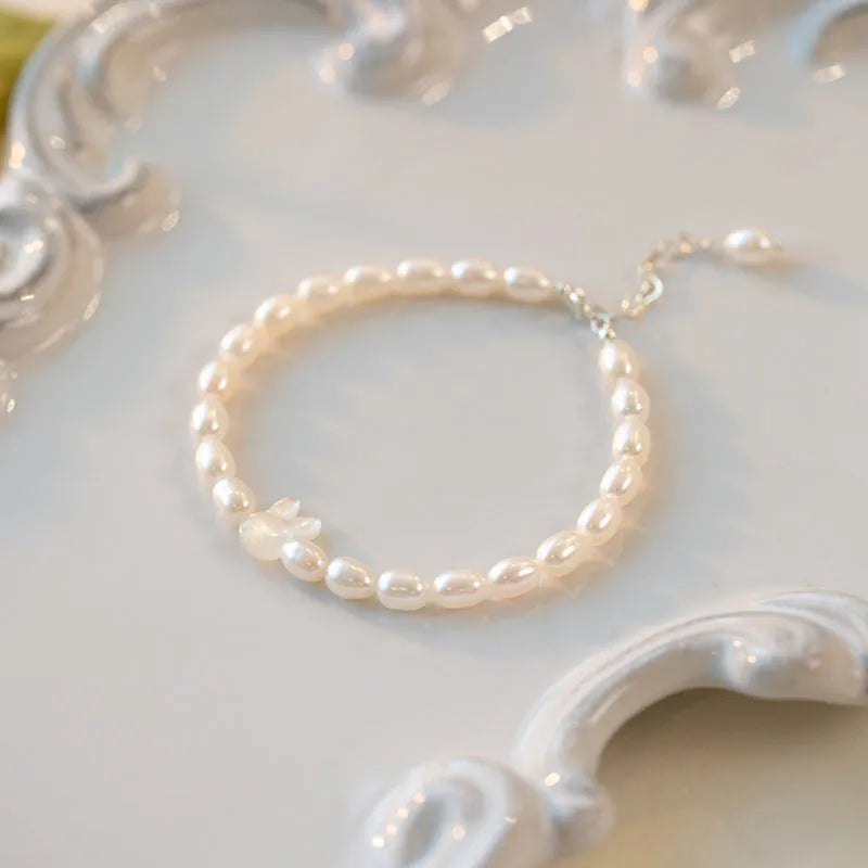 White shell bead bracelet with silver rabbit charm on elastic string