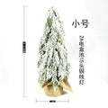 Small 24-inch white snow spray Christmas tree with integrated lights on desktop