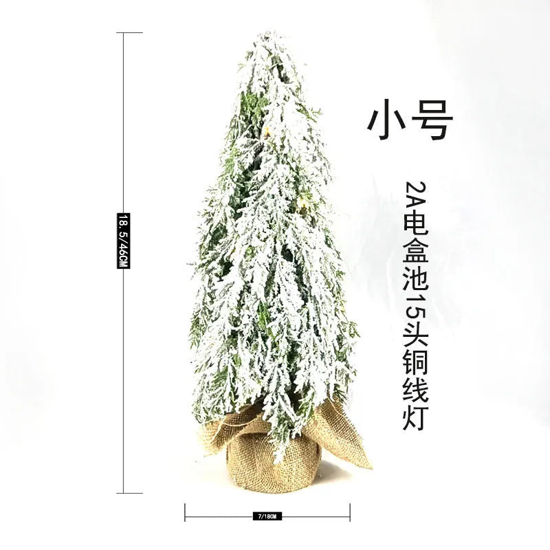 Small 24-inch white snow spray Christmas tree with integrated lights on desktop
