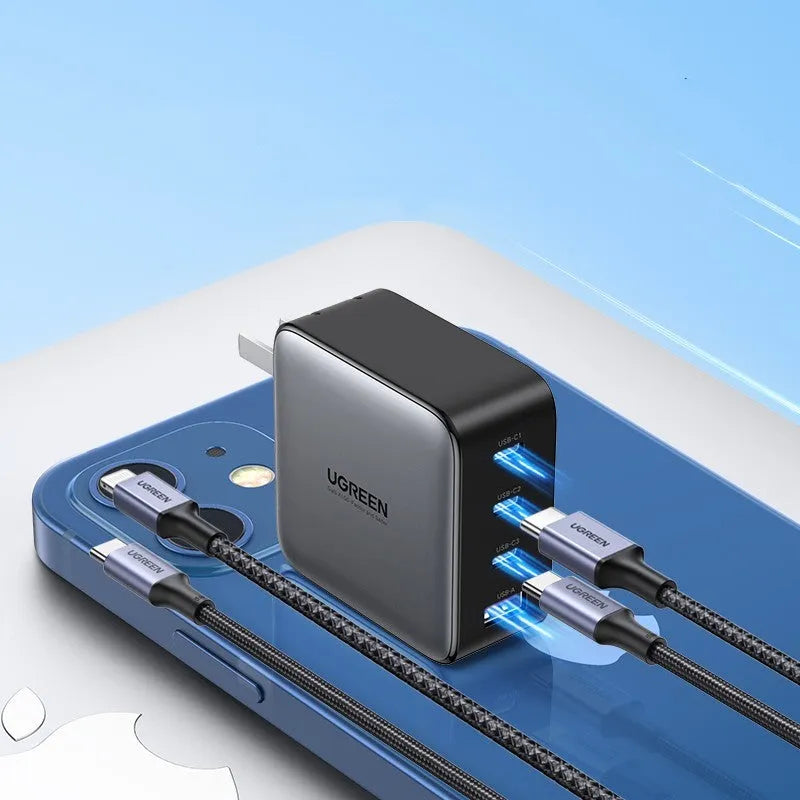 100W Gallium Nitride fast wall charger with USB-C port on a desk next to a laptop.