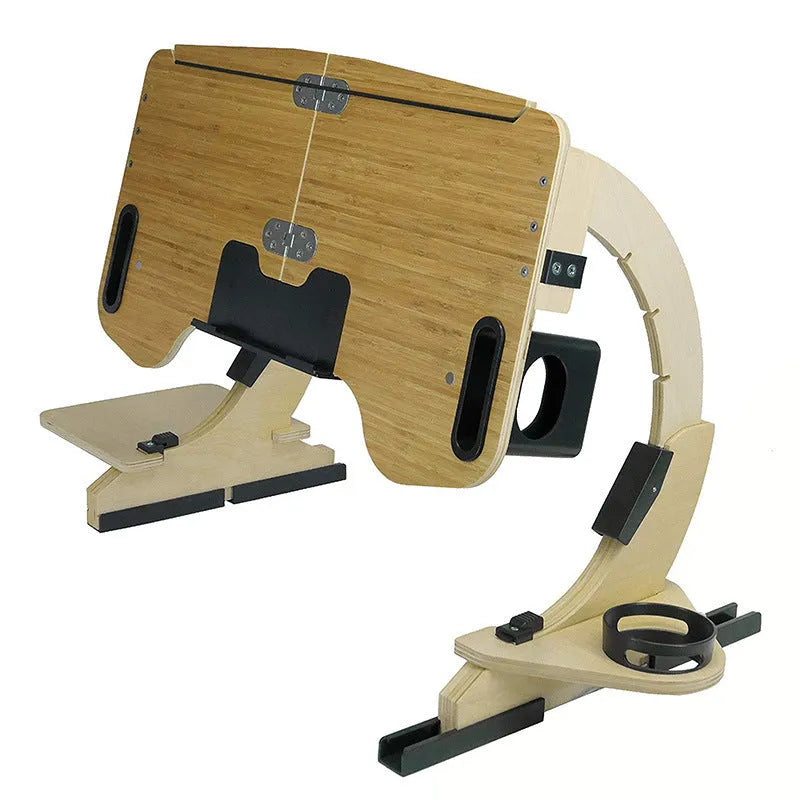 Wooden folding computer desk with adjustable angle shown on a bed in black finish.