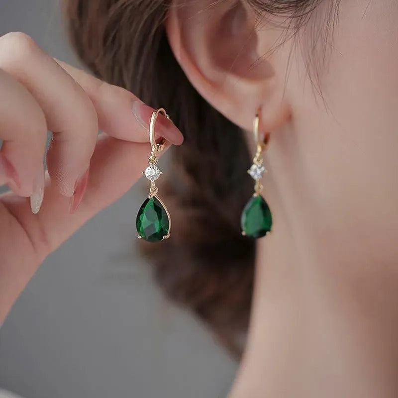 A pair of geometric green teardrop-shaped alloy drop earrings on a white background.