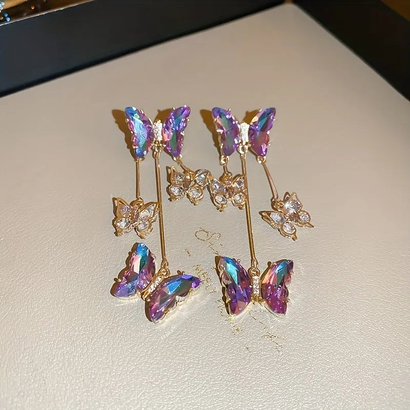 A pair of silver needle blue purple butterfly tassel earrings with crystal flowers on an alloy base.