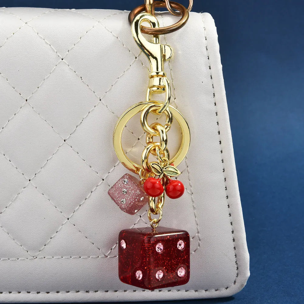 Square metal keychain pendant featuring a vintage cherry red and white two-tone dice pattern.