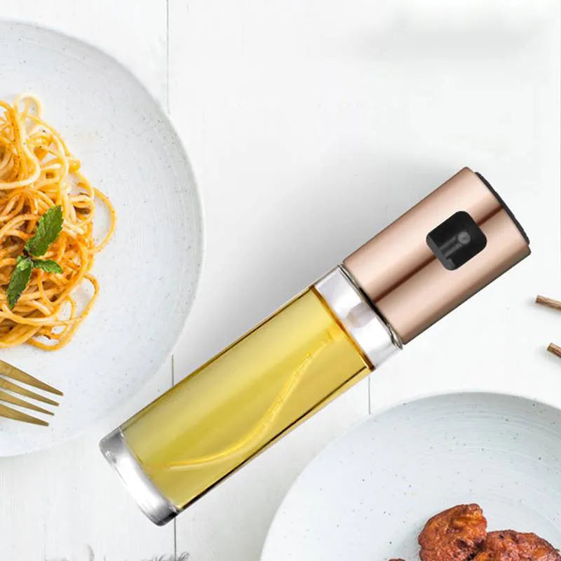 Gold push-type oil and vinegar spray bottle made of ABS plastic and glass with pump top.