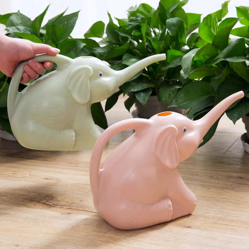 Pink baby elephant-shaped watering can with a long nozzle and bottle-style handle on a table.