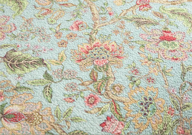 Blue American style floral bird quilted cotton bedspread set on a bed