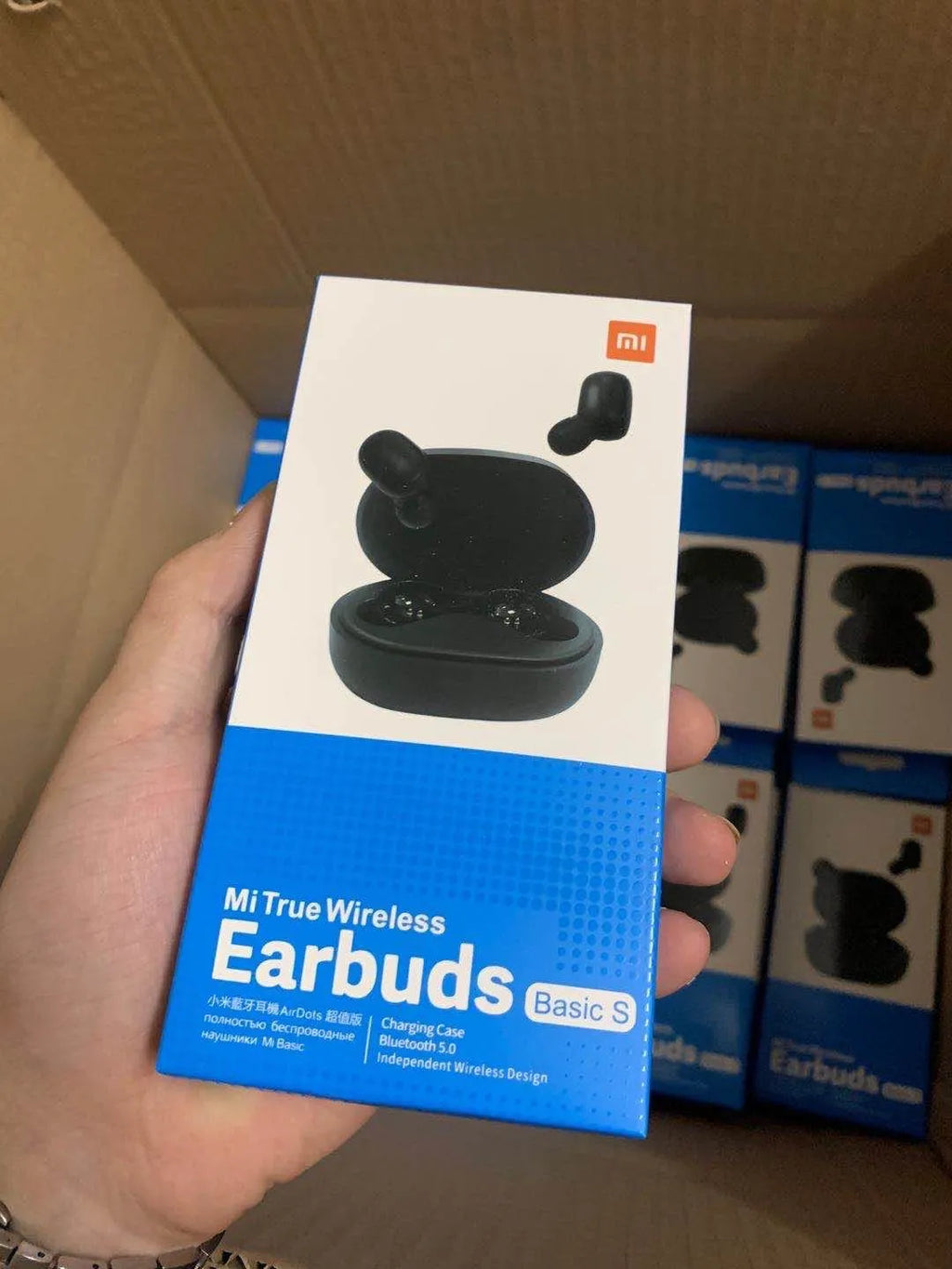Redmi AirDots black true wireless earbuds and charging case on a table.
