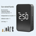 Compact black wireless digital tyre inflator pump with screen, hose, and multiple nozzles on a table