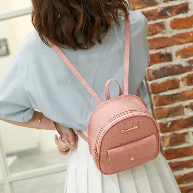 A compact black PU women's backpack purse with a zipper, shown as a small shoulder bag.