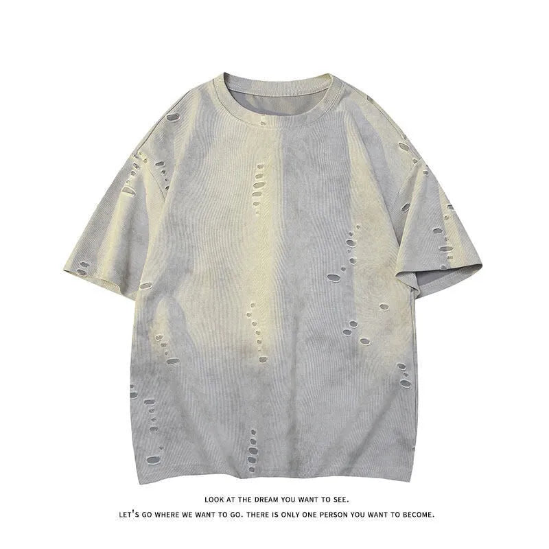 Men's blue loose-fit distressed short-sleeve t-shirt with ripped fabric detailing on a casual backdrop.