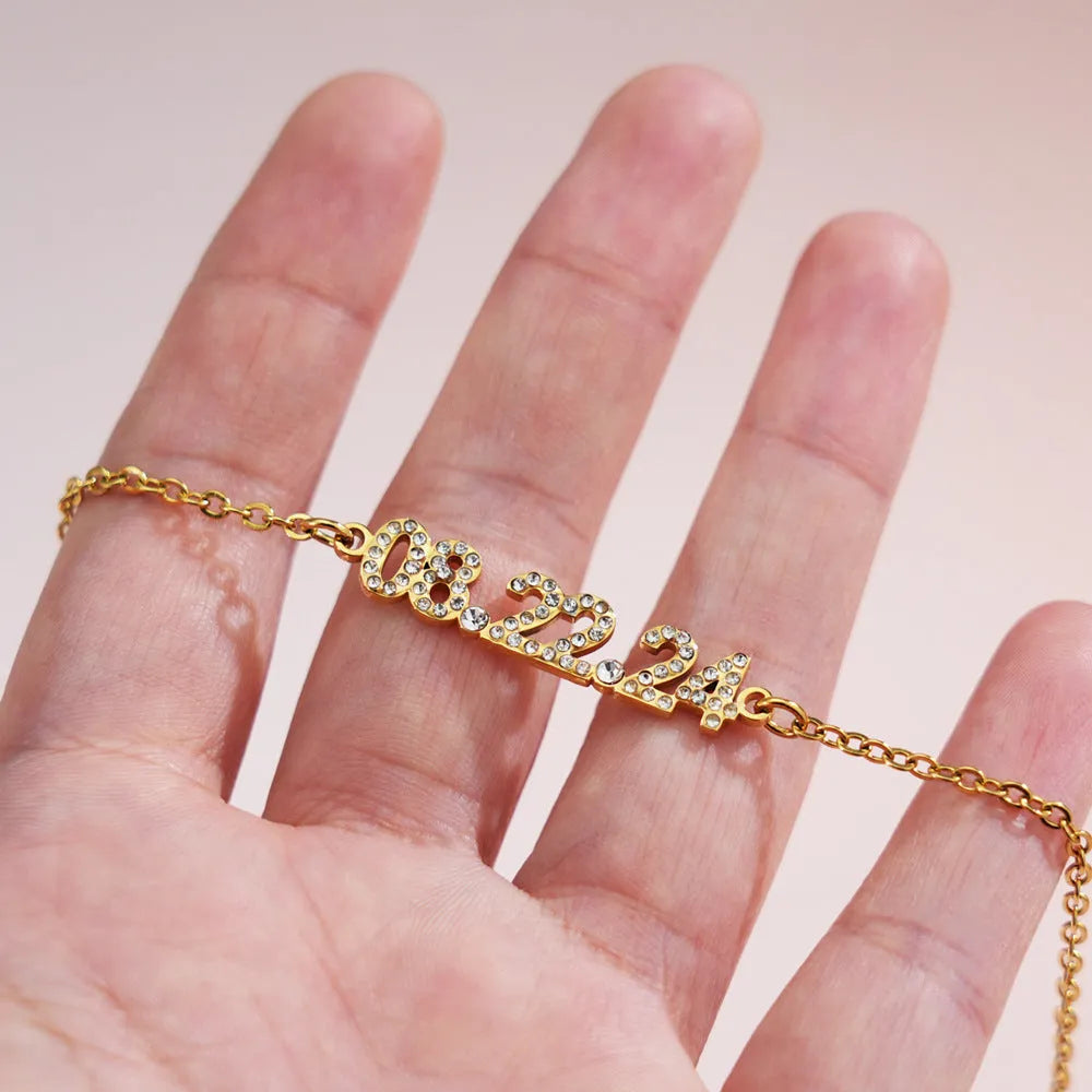 Stainless steel digital bracelet with diamond-set number display on wrist.