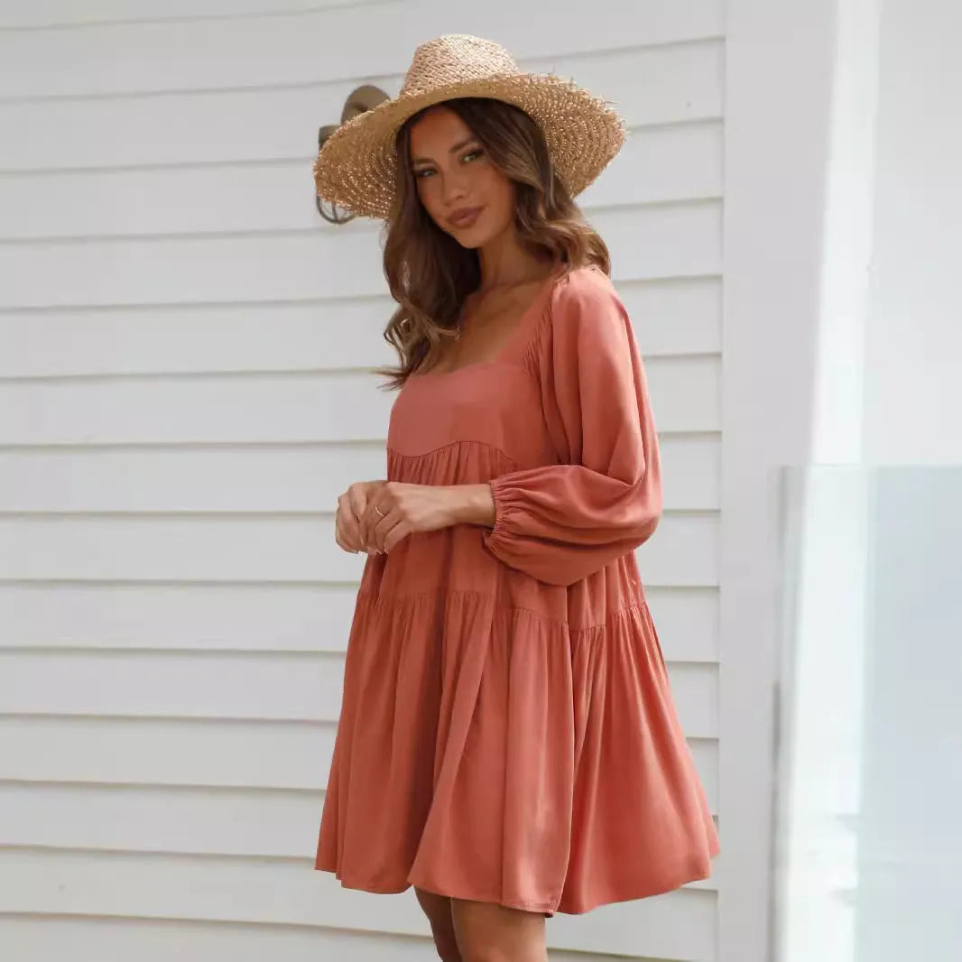 Orange red children's backless dress with square collar and puff sleeves on a mannequin.