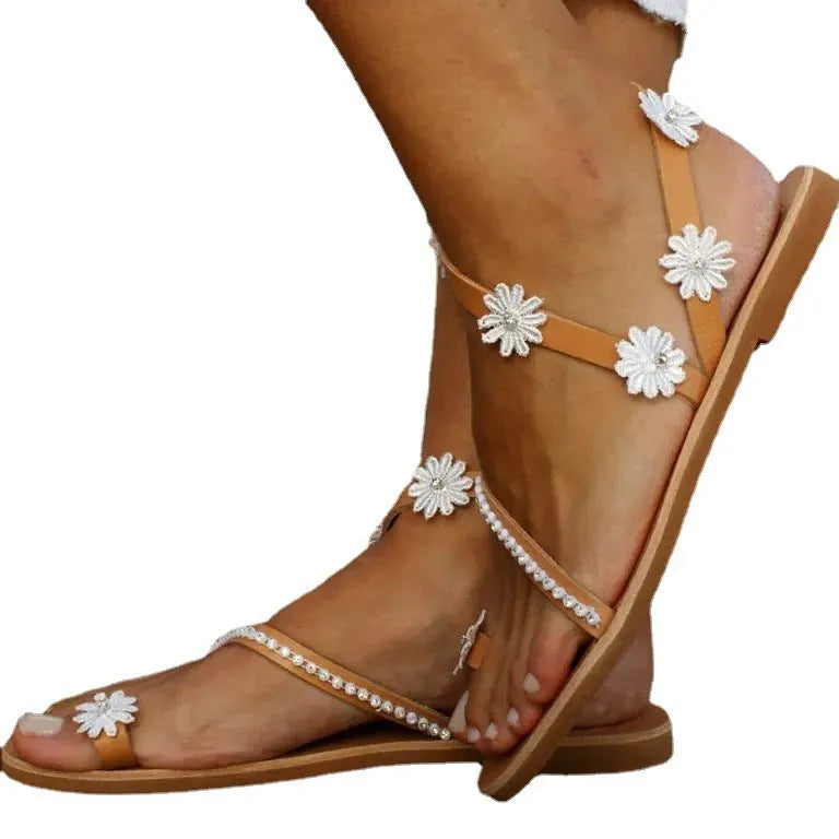 Brown women's Roman sandals with floral embroidery, flat rubber sole, and sleeve-on design.