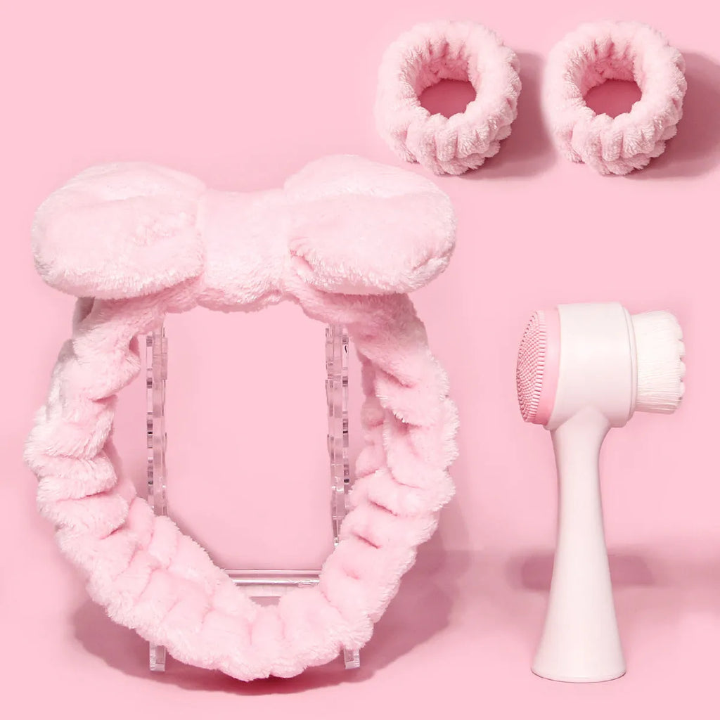 Purple, grey, white, and pink facial brush set with coral fleece hair band and nylon bristles.