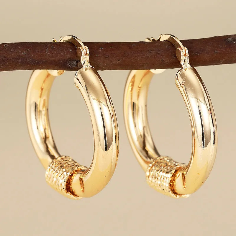 Women's copper geometric earrings with ring and line design elements in gold colours