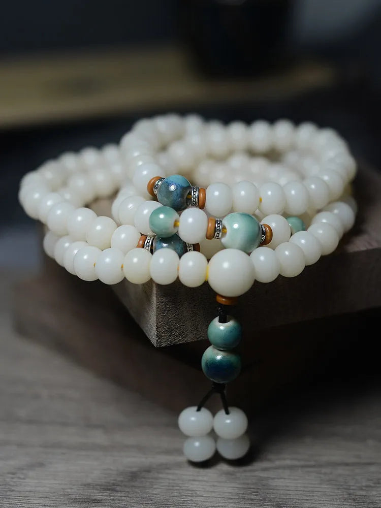 White jade and bodhi seed beaded bracelet with 108 flat round beads in four sizes.