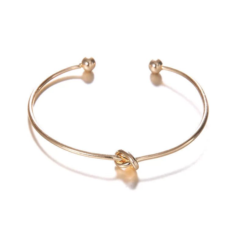 Women's gold vintage cuff bracelet with knotted arrow design in electroplated alloy