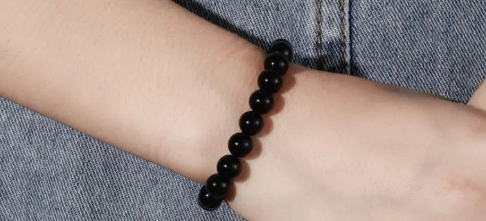 Geometric black agate bead bracelet with elastic cord, showing 8mm bead size detail.