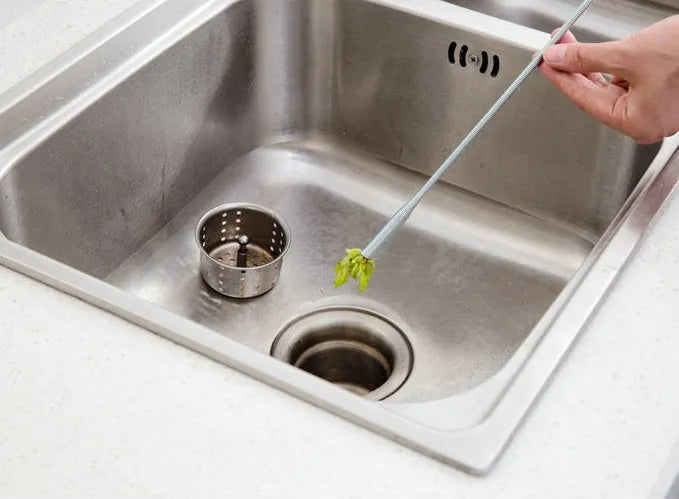 Black flexible sewer dredger spring drain cleaning tool with a textured grip on a white background.