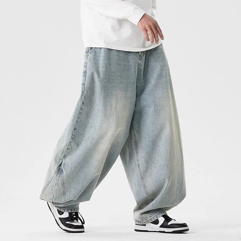 Men's plus size light blue baggy wide-leg jeans on a hanger, showing straight leg and low waist.