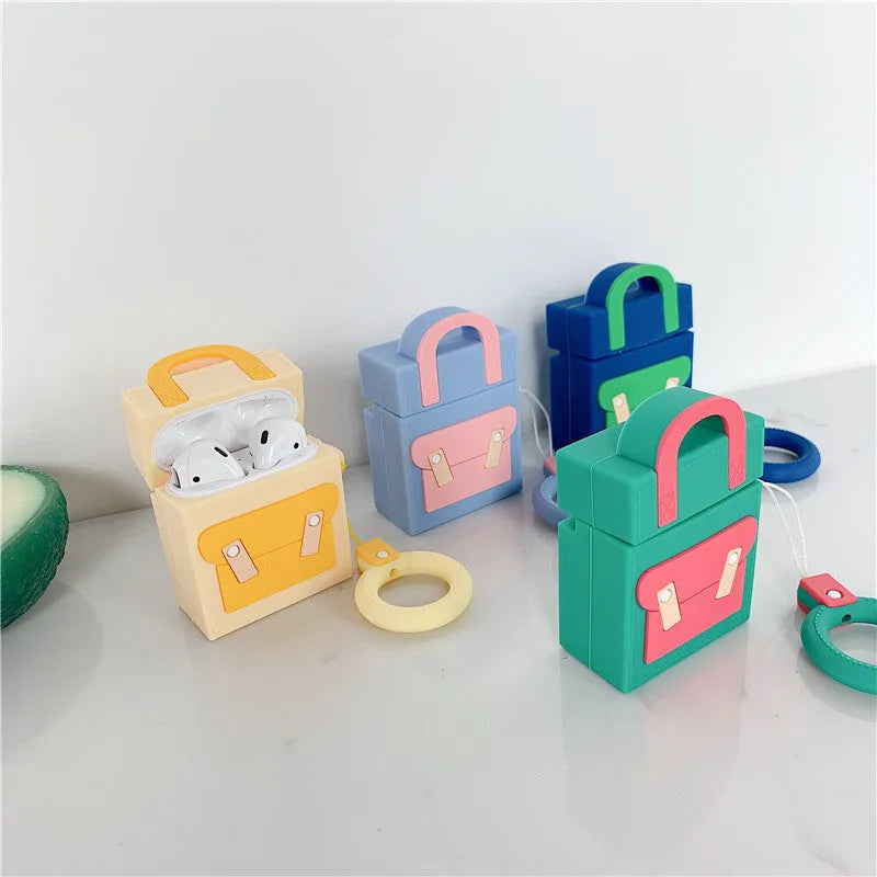 Silicone protective sleeve for AirPods 1 and 2 charging case with hanging ring, available in dark blue, green, purple, and yellow colours