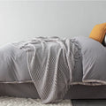 Small light grey polyester nap blanket folded, showing its texture and 127x170 cm size.