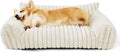 Beige corduroy fleece pet couch with high backrest and sides on a wooden floor.