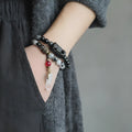 Ethnic black hair bracelet with white crystal tassel featuring bend and lace craftsmanship