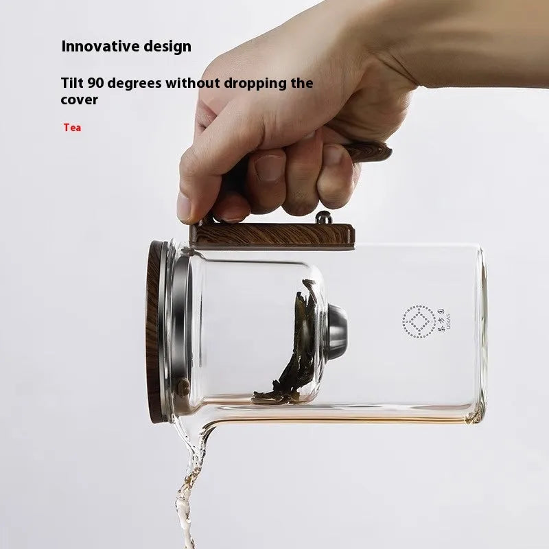 Glass teapot with wooden handle showing magnetic separation mechanism for loose leaf tea brewing