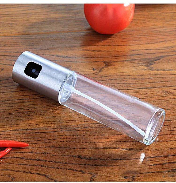 Gold push-type oil and vinegar spray bottle made of ABS plastic and glass with pump top.