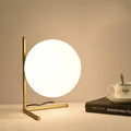 Creative glass desk lamp with three-tone LED lighting on a wooden desk.