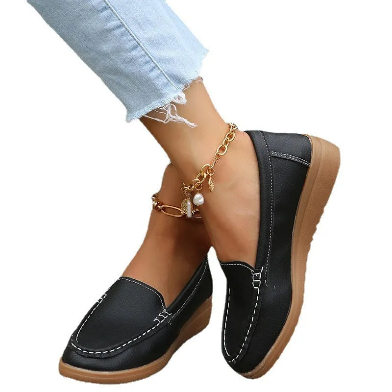 Women's black PU leather loafers flats with round toe and car suture detailing on a white background