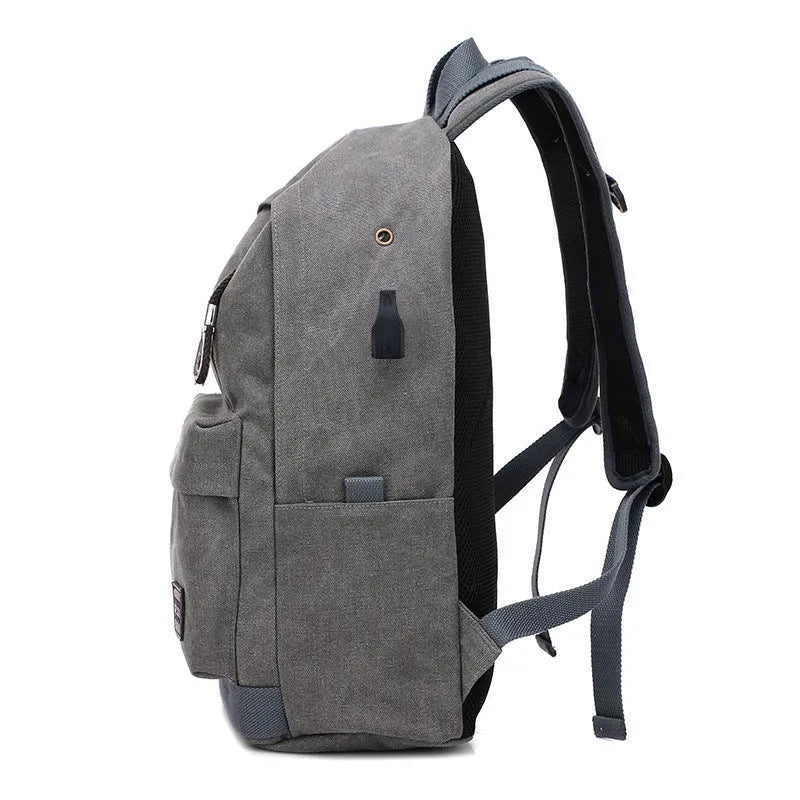 Canvas backpack with USB charging port showing laptop compartment and multiple pockets
