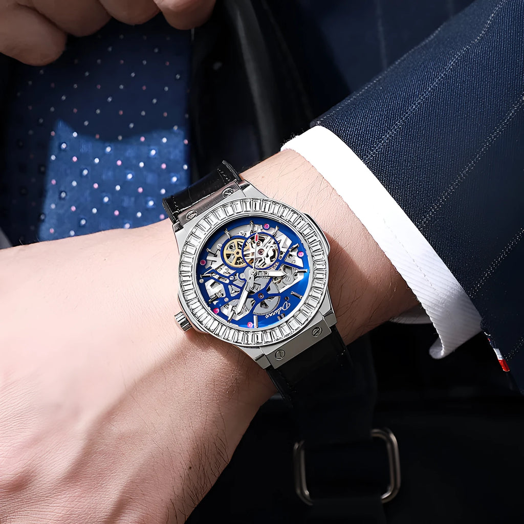 Automatic diamond studded skeleton men's watch with white shell case and blue dial on leather strap.